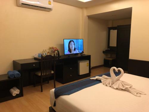 a hotel room with a bed and a television at Samui Mermaid Beachfront in Bang Rak Beach