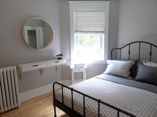 a bedroom with a bed with a mirror and a window at Beautiful, Clean, Quiet 2 BR-In Downtown Ottawa. Parking, WIFI and Netflix Included in Ottawa