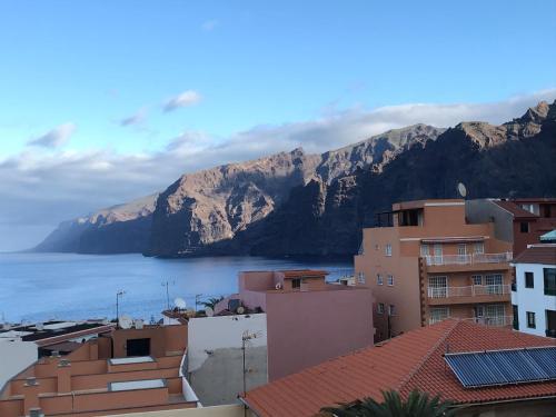 a view of a city with mountains in the background at Sunset Oasis of Los Gigantes in Puerto de Santiago