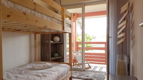 a bedroom with a bunk bed and a balcony at Apartment Cap Larros in Gujan-Mestras