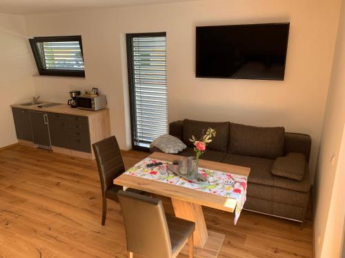 a living room with a table and a couch at Apartments MountainView in Maishofen