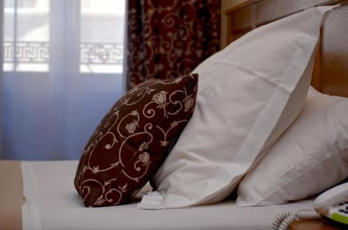 a brown and white pillow sitting on top of a bed at Hôtel Héliot, Cosy Places by Charme & Caractère in Toulouse