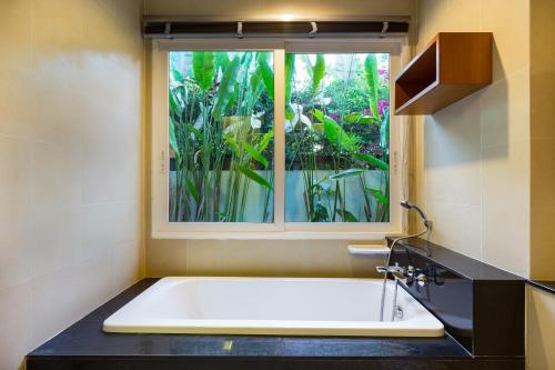 a bath tub in a bathroom with a window at Villa Jasmine in Rawai Beach
