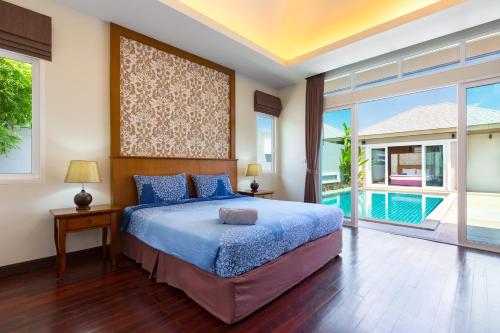 a bedroom with a large bed and a pool at Villa Jasmine in Rawai Beach