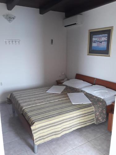 two beds in a room with two papers on them at Apartman Grospic in Cesarica