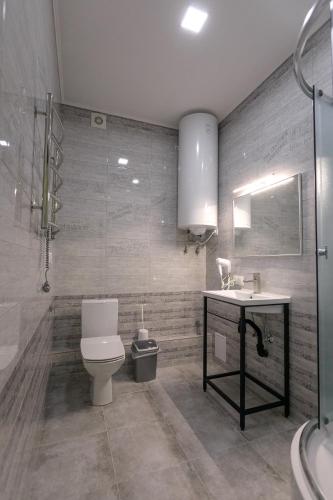 a bathroom with a toilet and a sink and a shower at Motel Sun Lit in Ivano-Frankivsʼk