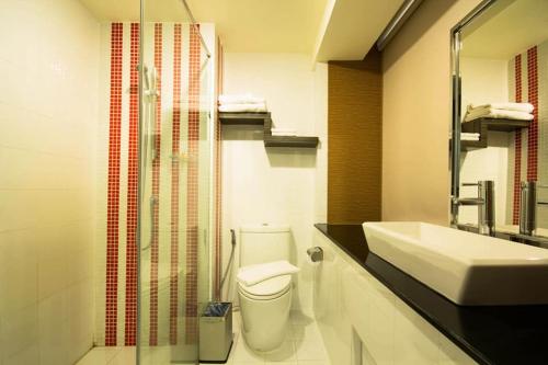 a bathroom with a toilet and a sink and a shower at Dragon River Avenue in Phitsanulok