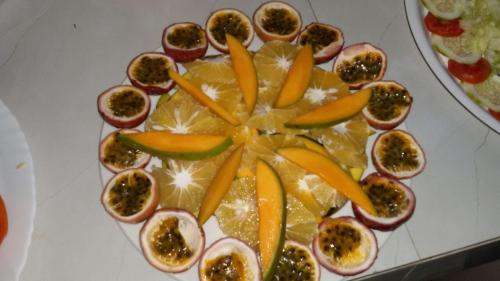 Un plato con naranjas y otras frutas encima. en Casa Umoja, en Nungwi