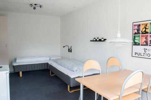 Habitación con cama, mesa y sillas. en Pulzion - Sportshotel en Kolding