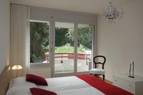 a bedroom with a bed and a large window at Exclusive Central Apartment in Basel