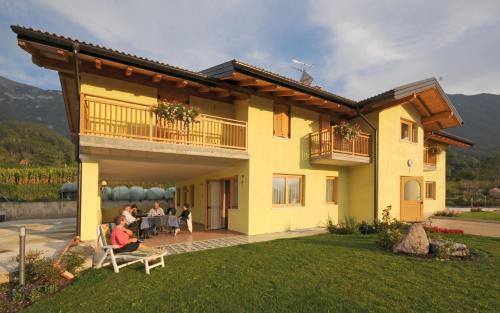 a group of people sitting outside of a house at Agritur Campo Fiorito in Dro