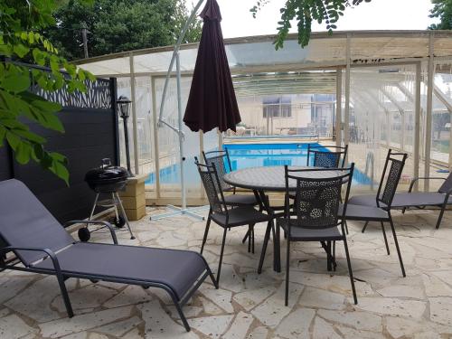 a patio with a table and chairs and a swimming pool at LE GITE DE RICHEMONT in Lachapelle-Saint-Pierre