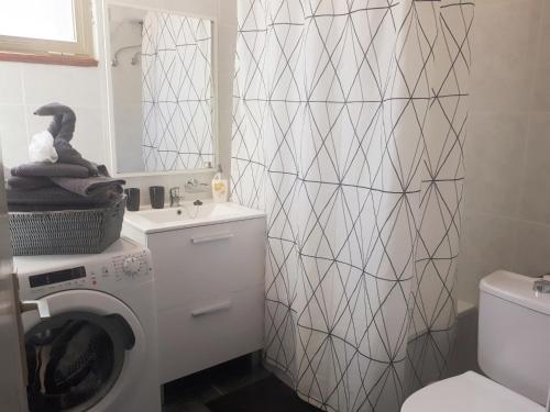 a bathroom with a washing machine and a toilet at Apartamento Any in Puerto Naos