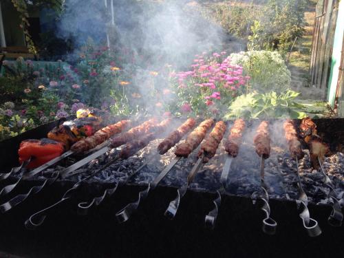 a bunch of meat on a grill with tongs at Arevik BB in Chʼiva