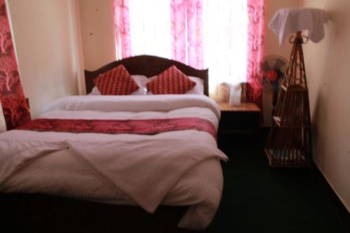 a bedroom with a bed with red and white pillows at Best Hostel in Kathmandu