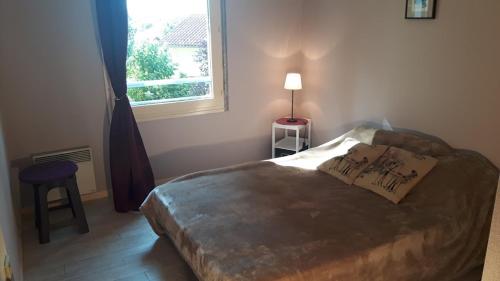 a bedroom with a large bed and a window at Appart T3 central calme proche Thermes pour cures/vacances in Saint-Paul-lès-Dax