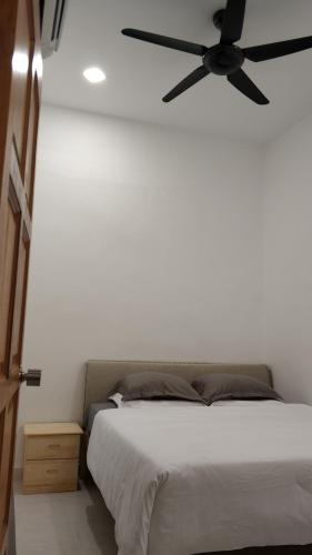 a bedroom with a bed with a ceiling fan at Mersing little homestay with free WIFI in Mersing