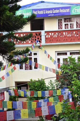a building with a fence with prayer flags in front of it at Best Hostel in Kathmandu