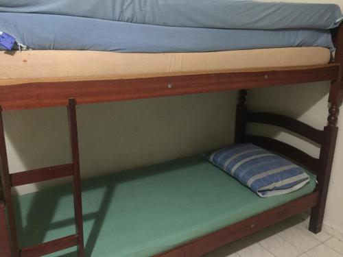 a bunk bed with a pillow on the bottom bunk at Casa em frente à praia Boracéia in Boracéia