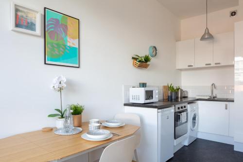 a kitchen with a wooden table and a counter top at Stylish Central Brighton Apartment 500 m from Brighton Beach in Brighton & Hove