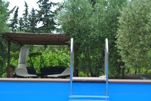 a swimming pool with a gazebo and chairs at Campo del Rosario in Montescudaio