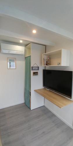 un salon avec une grande télévision à écran plat dans l'établissement Charmant studio à Noisiel entre Paris & Disneyland, à Noisiel