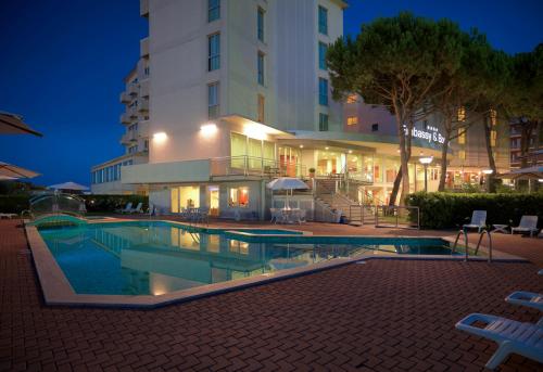 una piscina frente a un edificio por la noche en Hotel Embassy & Boston, en Milano Marittima