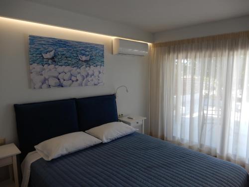 a bedroom with a blue bed and a window at Cielo mini suita in Karteros