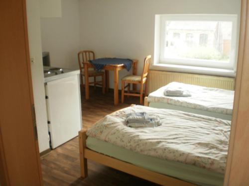 een kamer met 2 bedden en een tafel en stoelen bij Herzberg in Kleve