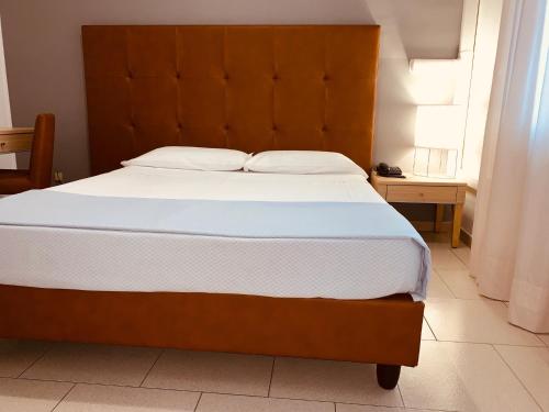 a bedroom with a large bed with a wooden headboard at Flying Hotel in San Maurizio Canavese