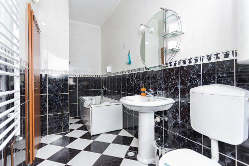 a black and white bathroom with a sink and a toilet at Hotel Dominus in Bijelo Polje