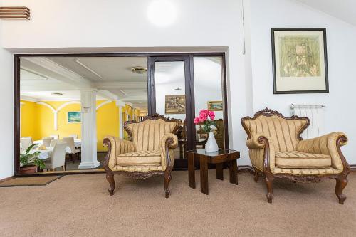 a living room with two chairs and a mirror at Hotel Dominus in Bijelo Polje
