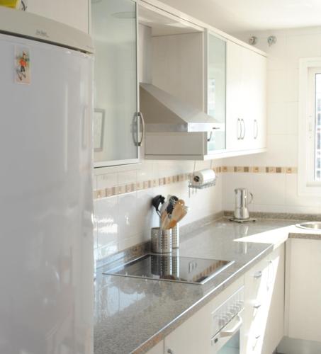 a kitchen with white cabinets and a stainless steel sink at Nuevo Rincón in Rincón de la Victoria