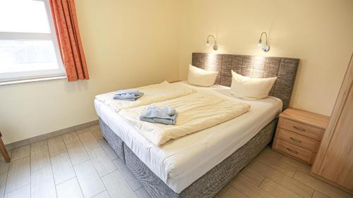 a bedroom with a bed with two towels on it at Vineta Ferienpark Usedom in Ostseebad Koserow
