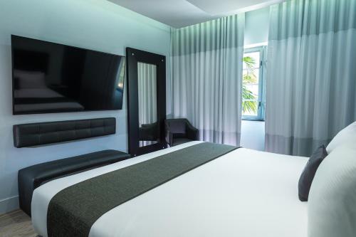a bedroom with a large white bed and a window at Kent Hotel in Miami Beach