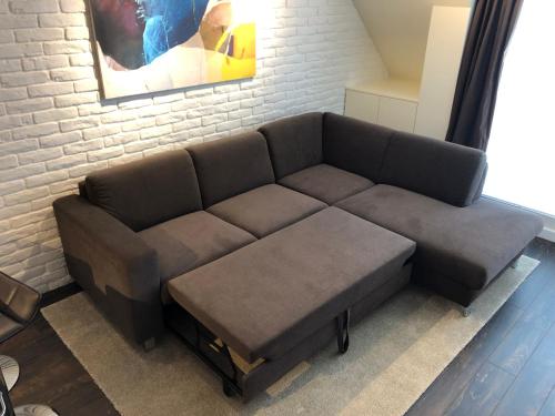 a couch in a room with a brick wall at Unique Luxurious Jacuzzi PENTHOUSE DUPLEX in City Center! 2 BATHS! FREE PARKING! in Sofia