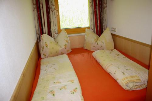 two beds in a small room with a window at Ferienwohnung Saalbach Fieberbrunn in Fieberbrunn
