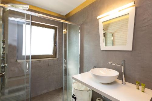 a bathroom with a sink and a glass shower at Arion Krini villa in Amnátos