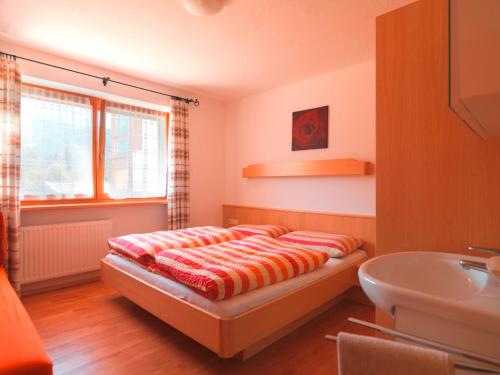 a bedroom with a bed and a sink in it at Ferienwohnung Saalbach Fieberbrunn in Fieberbrunn