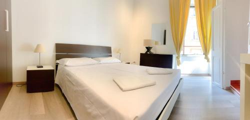 a bedroom with a large white bed and a window at Luxury barberini boutique Apartment in Rome