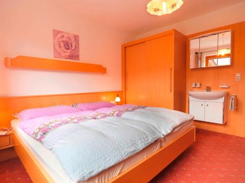 a bedroom with a large bed and a sink at Ferienwohnung Saalbach Fieberbrunn in Fieberbrunn