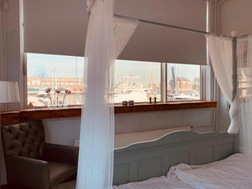 a bedroom with a window with a view of a harbor at BBDeRijkswerf in Den Helder