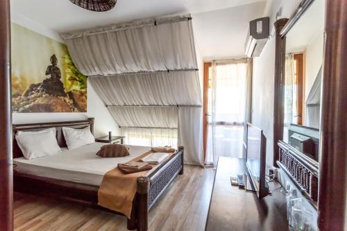 - une chambre avec un grand lit et une télévision dans l'établissement Lombardi Family Hotel, à Ruse