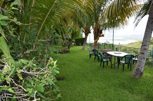 a table and chairs on the grass near the ocean at The Mayan Grouper in Suchitoto