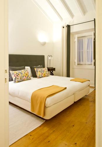 a bedroom with a large white bed with a mirror at Quinta Da Cabrita in Santarém