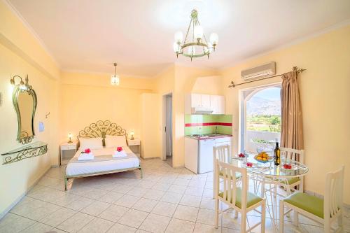 een woonkamer met een bed en een tafel en een keuken bij Palladion Hotel in Georgioupolis