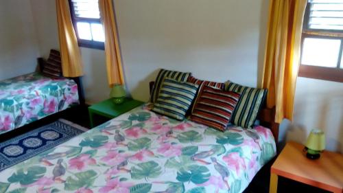 a bedroom with a bed with a floral comforter at chez Manu in Le Robert