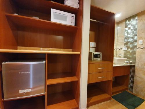 a bathroom with a closet with a microwave at El Mariscal Cusco in Cusco