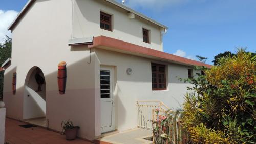 a white house with a red roof at chez Manu in Le Robert