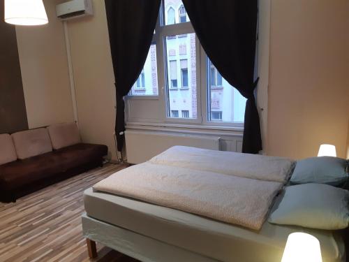 ブダペストにあるリヒテンシュタイン アパートメンツのベッドルーム1室(ベッド1台、窓、ソファ付)